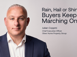Man in a suit with a neutral expression against a gray background. Text reads: Rain, Hail or Shine Buyers Keep Marching On.